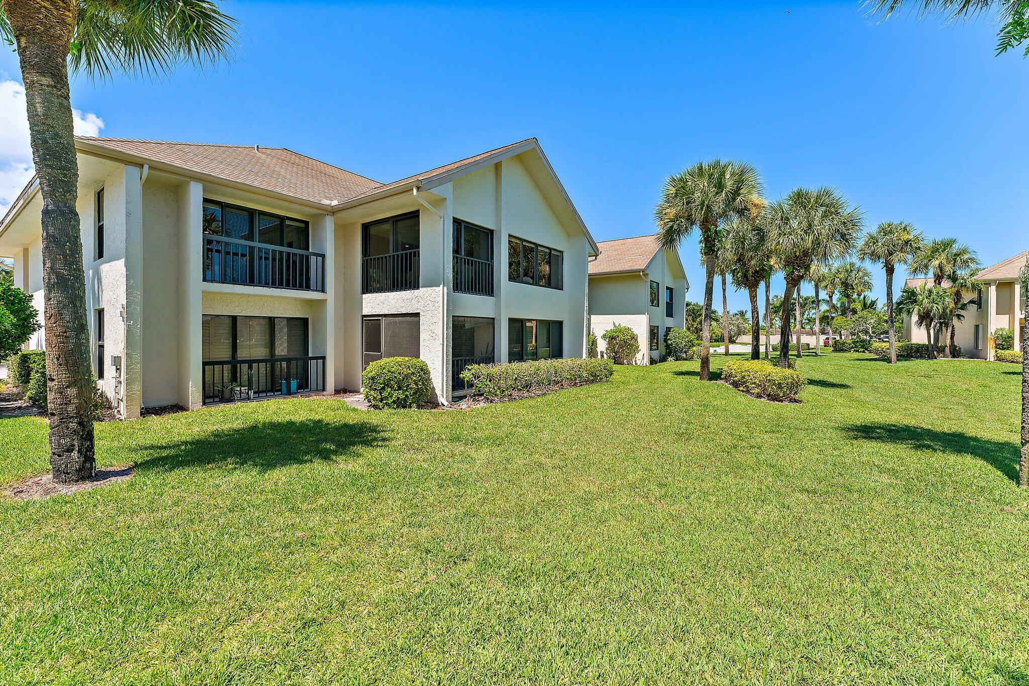 19101 Southeast Sea Turtle Court, Unit 202 Jupiter, FL 33469 - Photo 4 of 35 a front view of a house with a yard