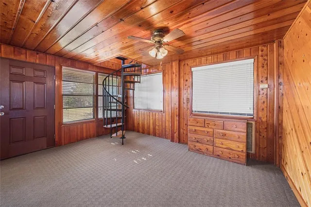 an empty room with windows and exposed radiator