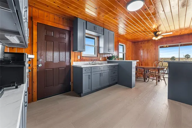 a kitchen with stainless steel appliances a sink cabinets and wooden floor