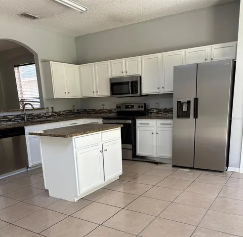 a kitchen with stainless steel appliances granite countertop a refrigerator and a sink