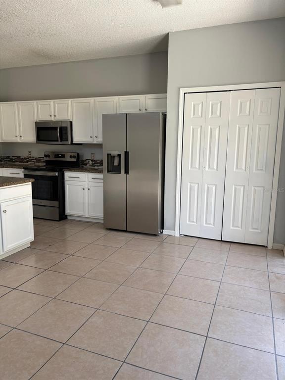 3078 Barbados Lane Haines City, FL 33844 - Photo 8 of 14 a kitchen with stainless steel appliances granite countertop a refrigerator and a sink