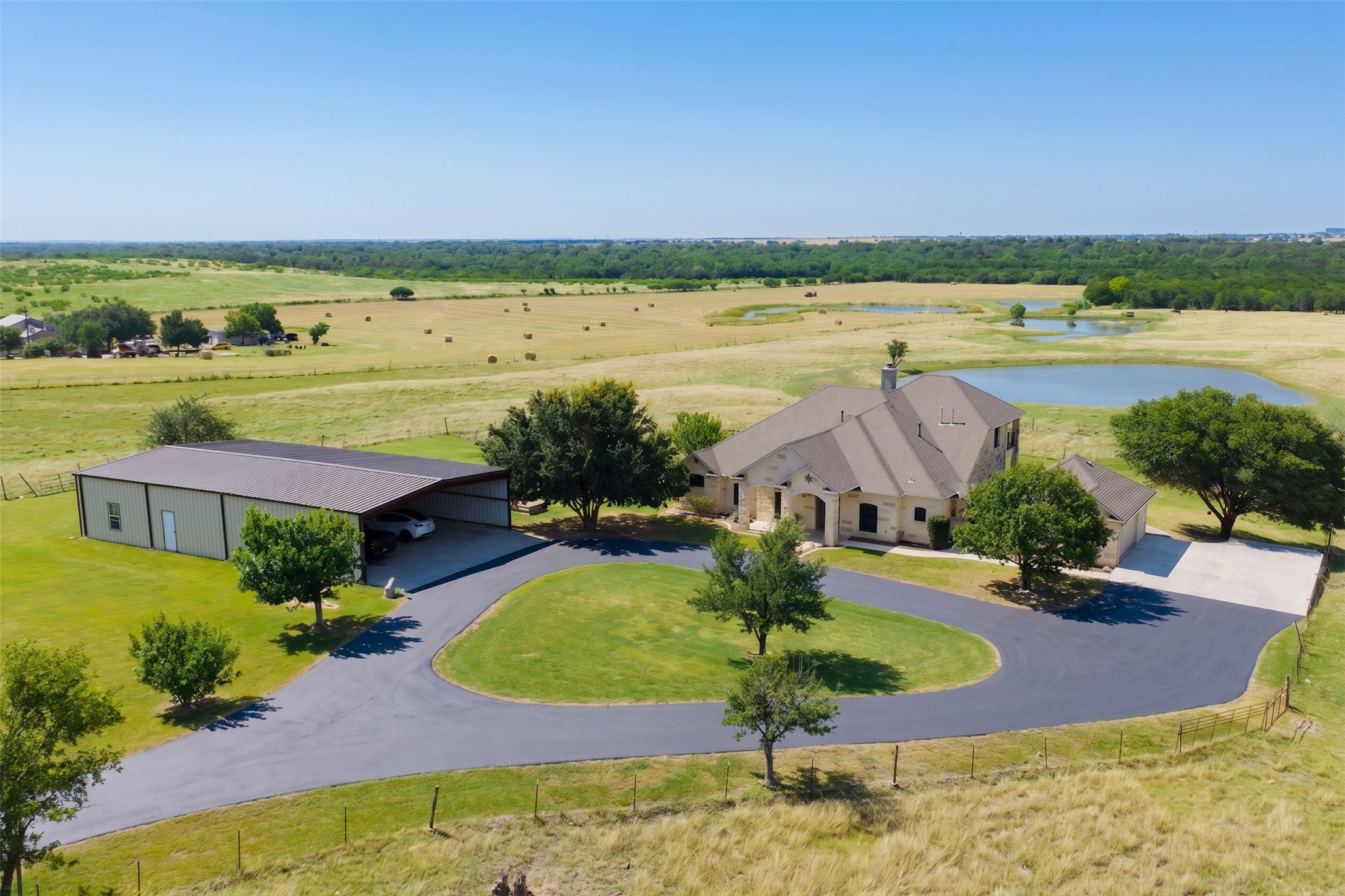 20145 Janak Road Coupland, TX 78615 - Photo 3 of 40 A sweeping aerial view showcases this stunning Texas ranch, featuring a beautiful two-story home, rolling hills and three picturesque ponds surrounded by abundant deer and native wildlife.