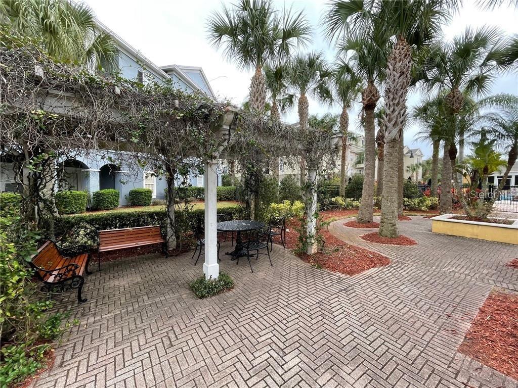 3611 Conroy Road, Unit 825 Orlando, FL 32839 - Photo 23 of 27 a view of a patio with table and chairs under an umbrella