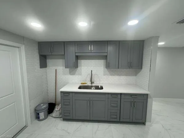 a kitchen with a sink a refrigerator and cabinets