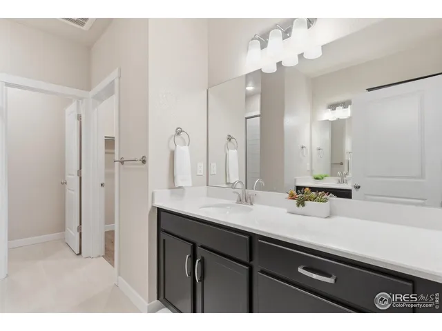 a bathroom with a sink double vanity granite and a mirror