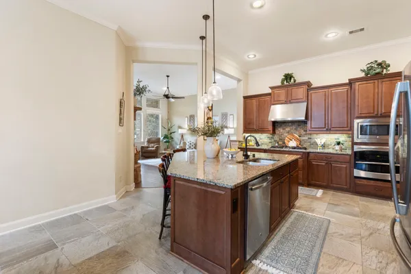 a kitchen with kitchen island granite countertop a sink counter top space appliances and a center island