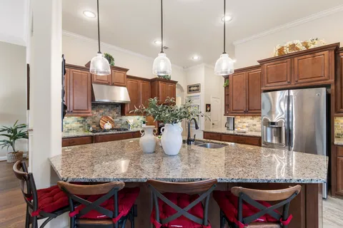 a kitchen with granite countertop a table a stove and chairs