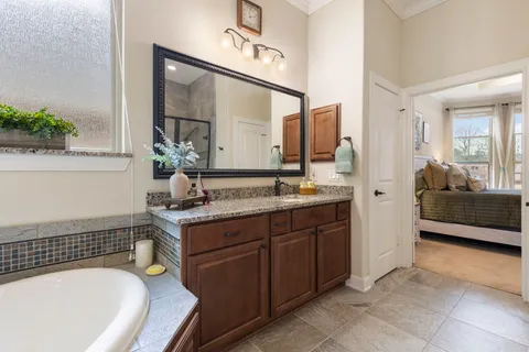 a spacious bathroom with a tub sink and mirror
