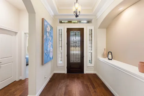 a view of a hallway with wooden floor and staircase