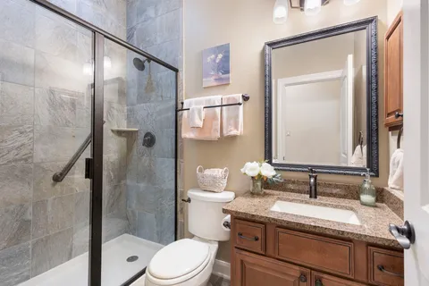 a bathroom with a granite countertop sink toilet and shower