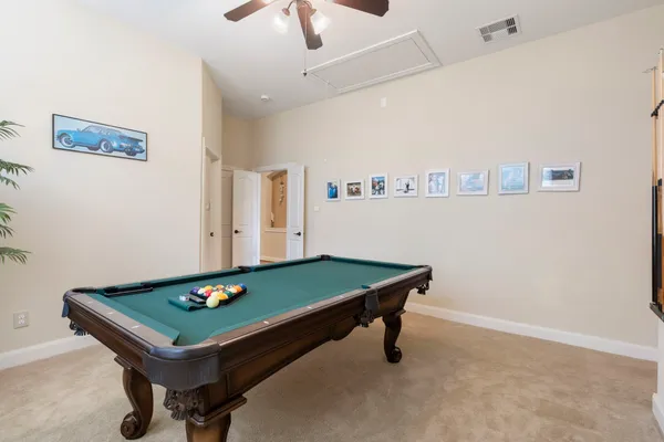 a room with pool table and windows