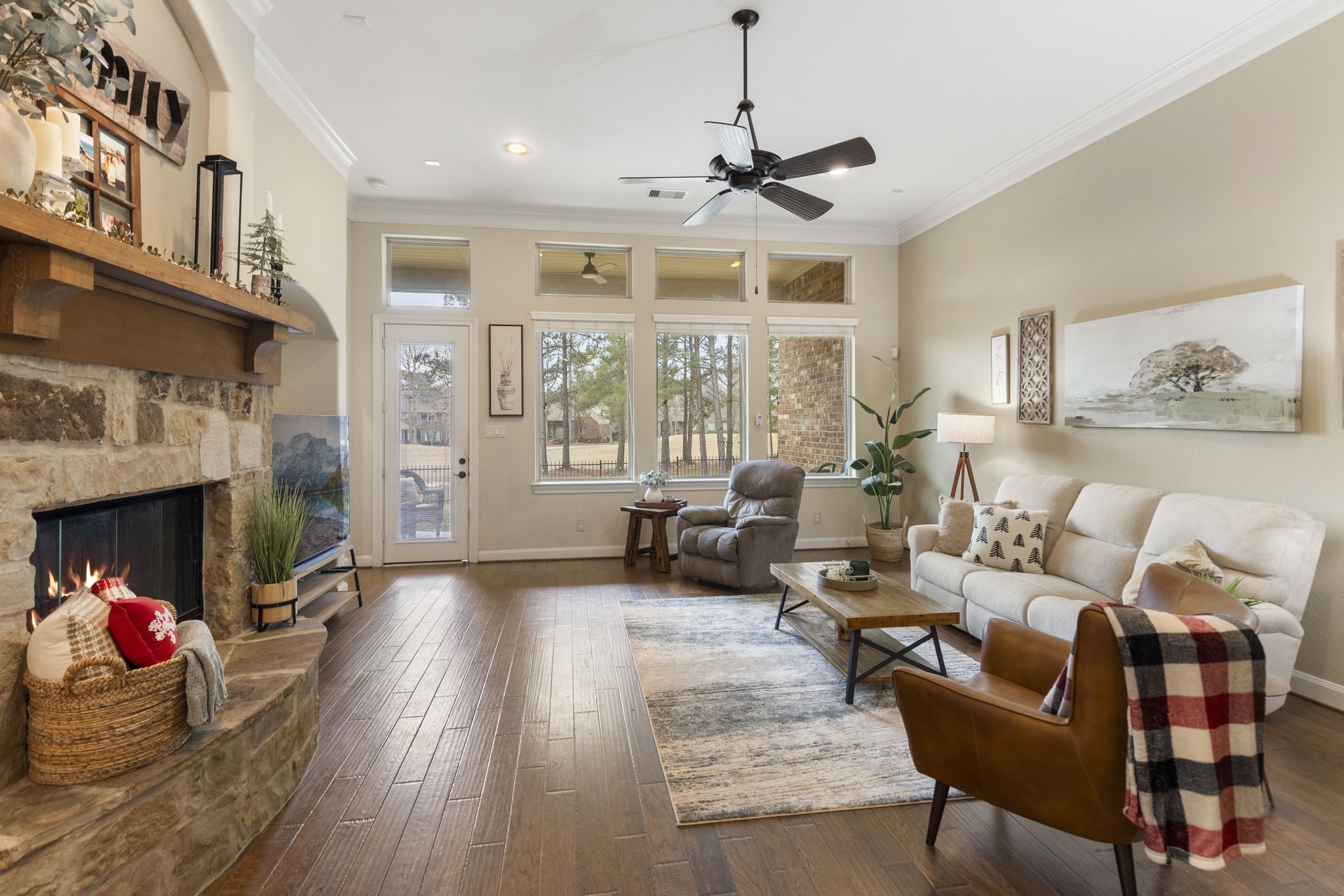 4787 Jackson Square Drive Conroe, TX 77304 - Photo 5 of 41 Step into a family room that checks every box for comfort, style, and togetherness. Gleaming hardwood floors set the stage for a warm, inviting ambiance, while a stunning wall of windows floods the space with natural light, creating a seamless connection to the outdoors.