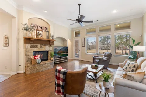 a living room with furniture a fireplace and a floor to ceiling window
