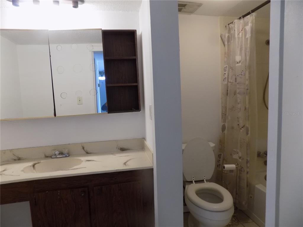 2811 Southwest Archer Road, Unit X 201 Gainesville, FL 32608 - Photo 15 of 29 a bathroom with a toilet a sink and mirror