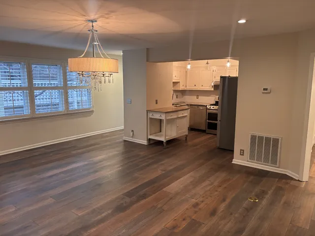 a kitchen with stainless steel appliances wooden floor and refrigerator