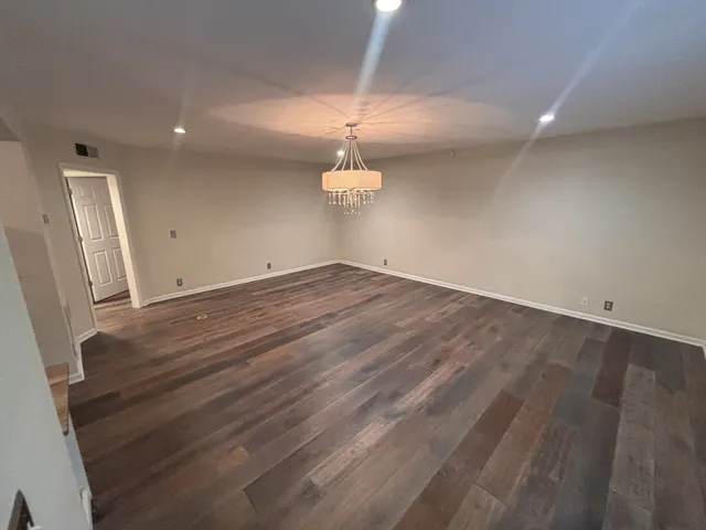 a view of a room with wooden floor and ceiling fan