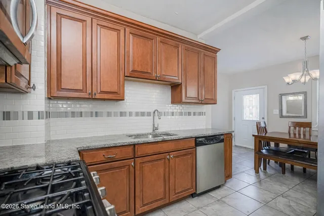 a kitchen with granite countertop a sink stove and cabinets