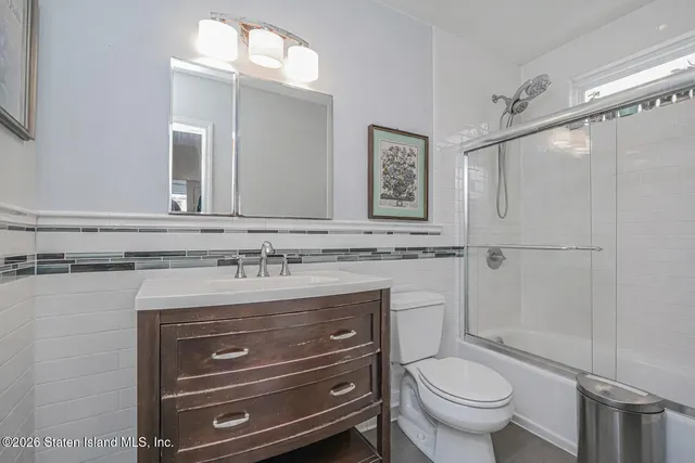 a bathroom with a granite countertop toilet sink and mirror