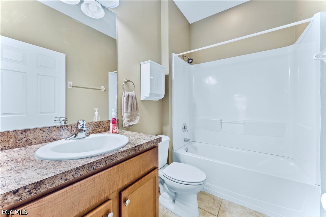 10781 Crossback Lane Lehigh Acres, FL 33974 - Photo 16 of 28 a bathroom with a granite countertop sink toilet and shower