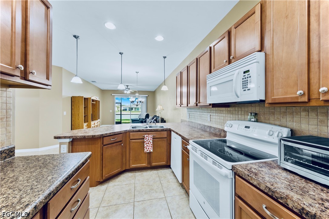 10781 Crossback Lane Lehigh Acres, FL 33974 - Photo 7 of 28 a kitchen with stainless steel appliances granite countertop a sink and dishwasher a stove top oven with wooden floor
