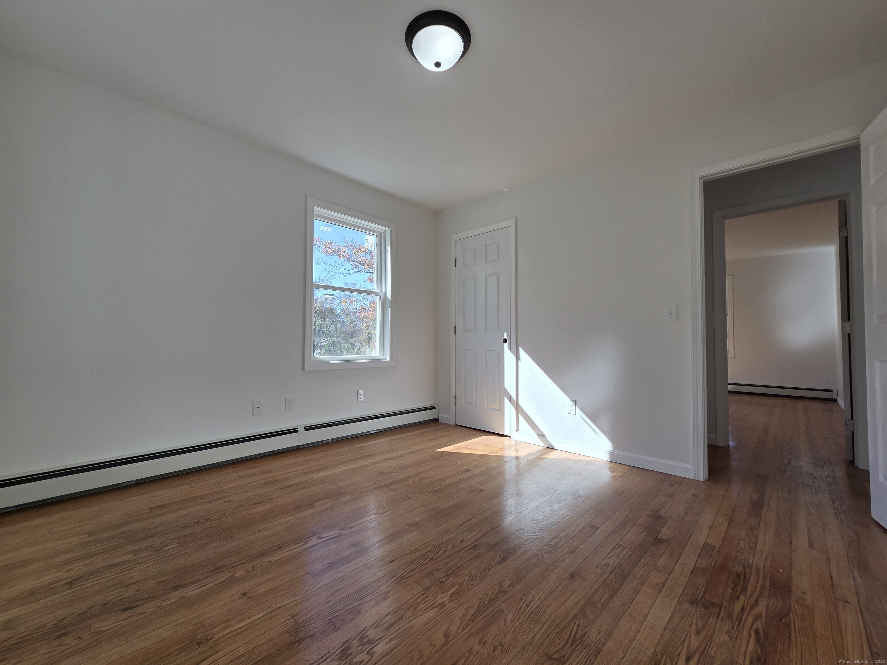 395 Bailey Hill Road Killingly, CT 06239 - Photo 20 of 36 an empty room with wooden floor and windows