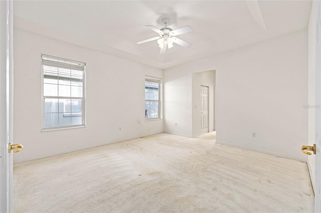 11621 Southwest 72nd Circle Ocala, FL 34476 - Photo 29 of 66 an empty room with windows and chandelier fan
