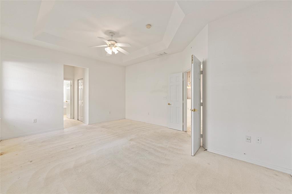 11621 Southwest 72nd Circle Ocala, FL 34476 - Photo 30 of 66 an empty room with chandelier fan and windows