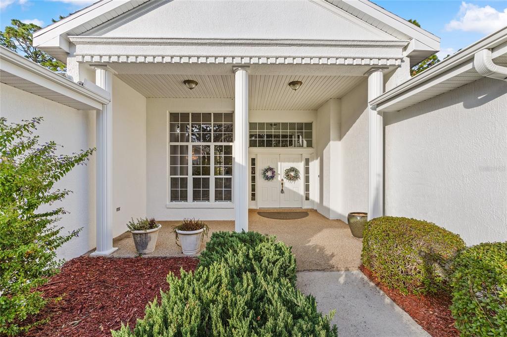 11621 Southwest 72nd Circle Ocala, FL 34476 - Photo 7 of 66 a front view of a house with a large window and potted plants
