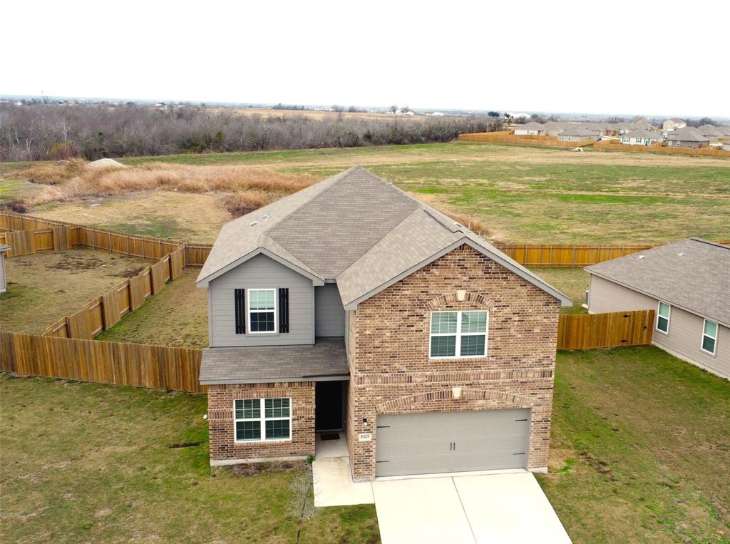 16429 Farmhouse Lane Elgin, TX 78621 - Photo 2 of 22 Two-story residence featuring a brick and siding exterior, an attached garage, and a fenced backyard