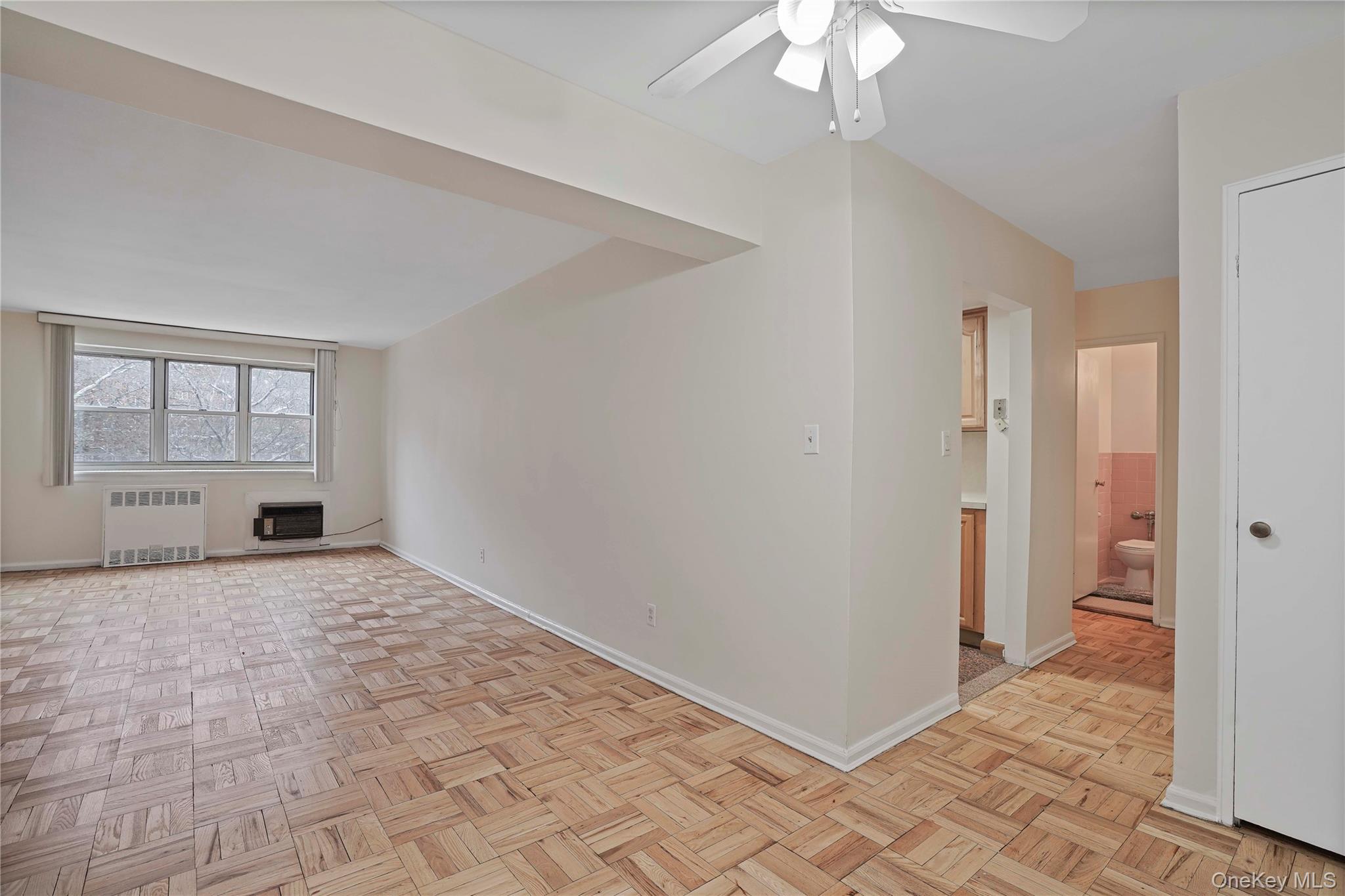 151-31 88th Street, Unit 1B Queens, NY 11414 - Photo 4 of 24 a view of a livingroom with a chandelier fan and windows