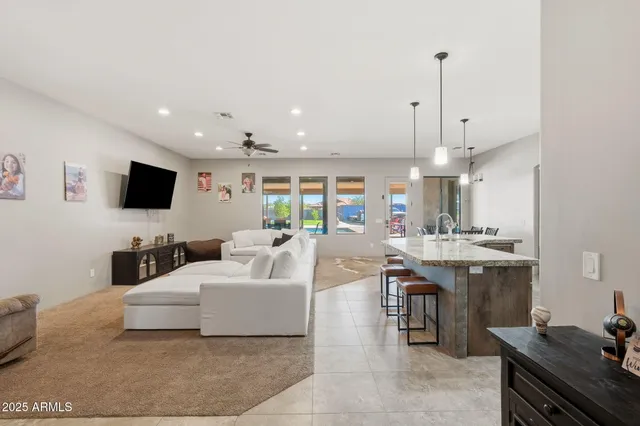 a living room with furniture a flat screen tv and kitchen view