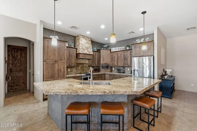 a kitchen with kitchen island a sink stove and refrigerator