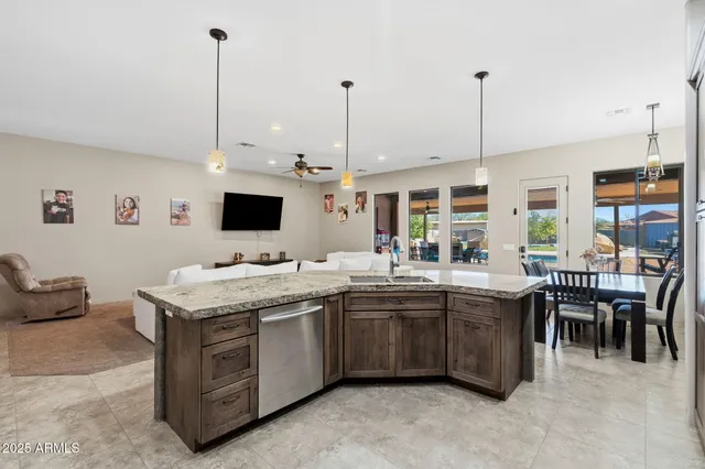 a kitchen with stainless steel appliances granite countertop a sink a stove and a wooden floors
