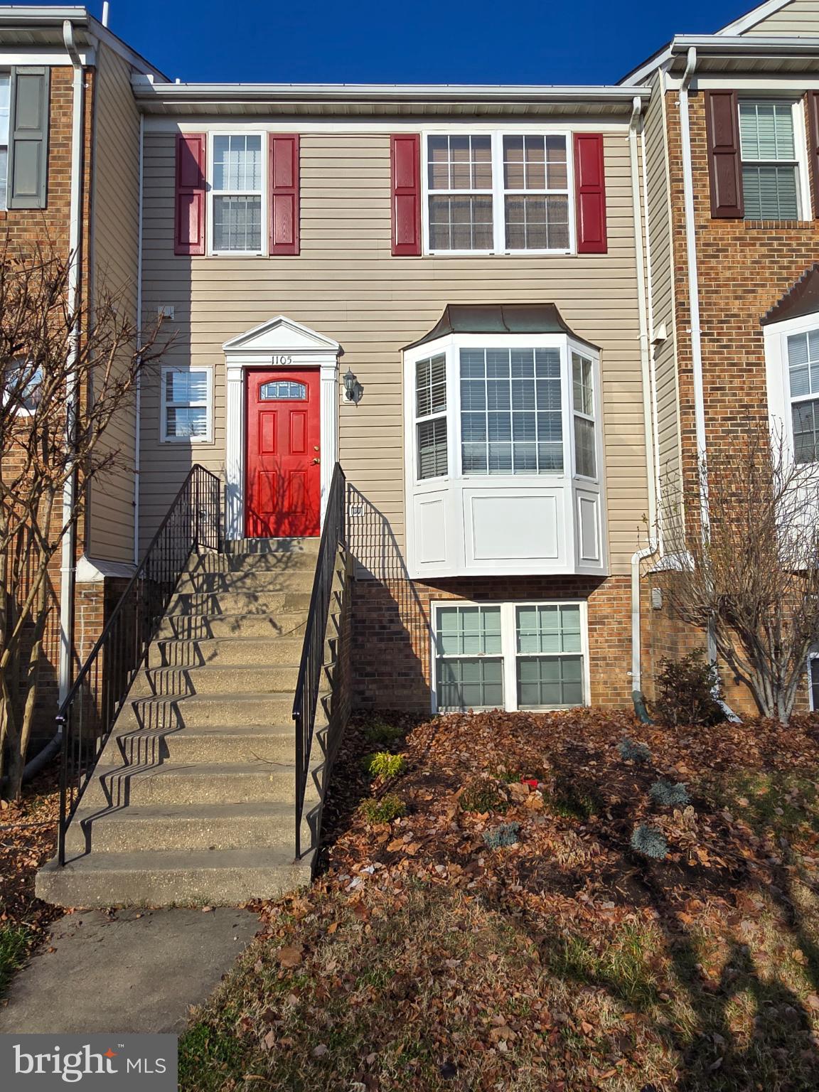 Charming townhouse with vibrant red door.