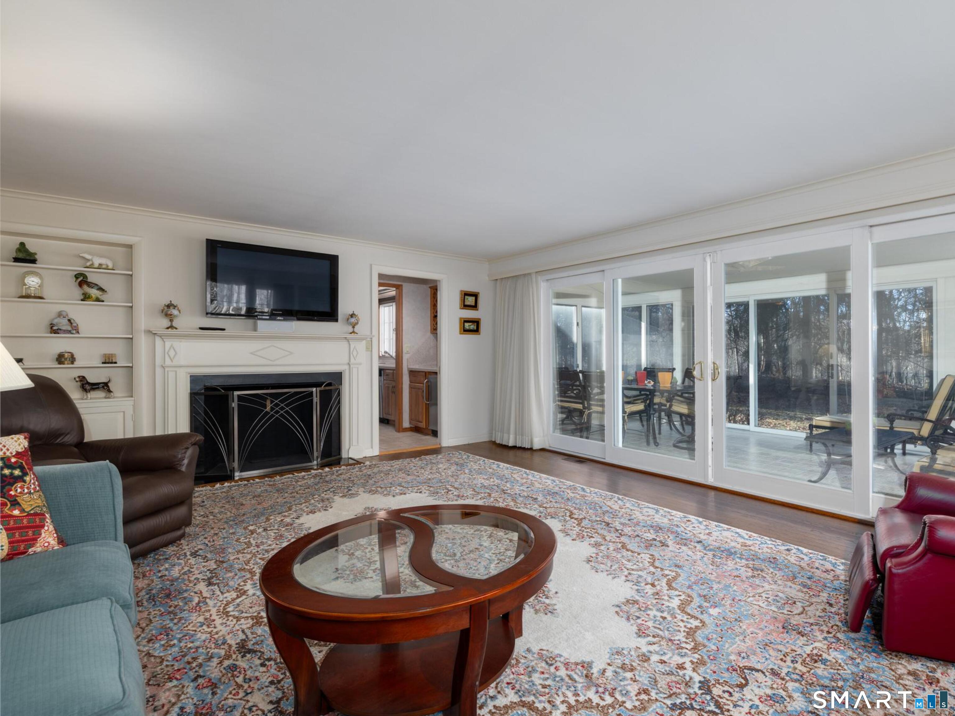 117 Crest Road Middlebury, CT 06762 - Photo 5 of 38 This classic living room has built-ins, a cozy fireplace and warm toned hardwood flooring. It can be open to the sunroom by an oversized sliding door too.