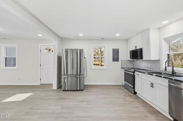 a kitchen with stainless steel appliances granite countertop a refrigerator and a stove top oven