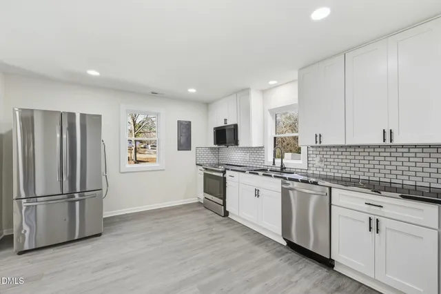a kitchen with stainless steel appliances granite countertop a refrigerator and a stove top oven