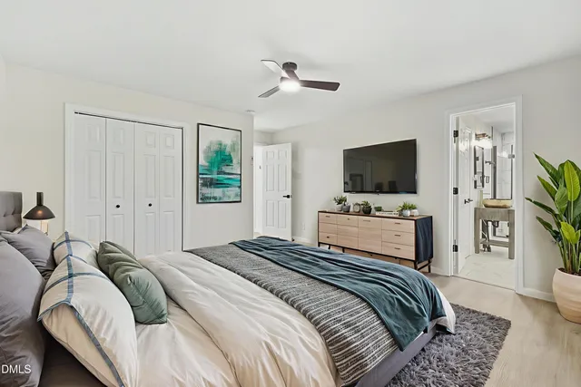a bedroom with a bed flat screen tv and a window