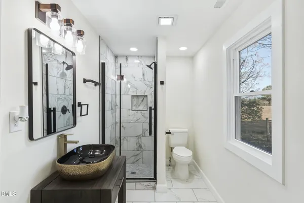 a bathroom with a sink a toilet and shower