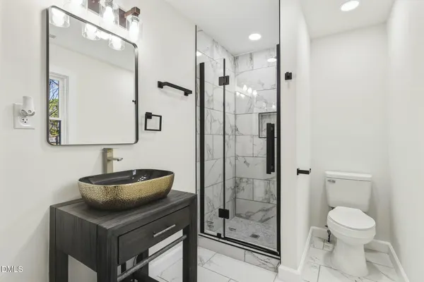 a bathroom with a sink toilet a mirror and shower