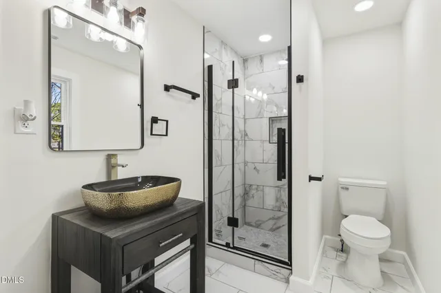 a bathroom with a sink toilet a mirror and shower