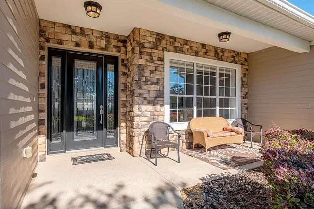 a living room with furniture kitchen view and a wooden floor