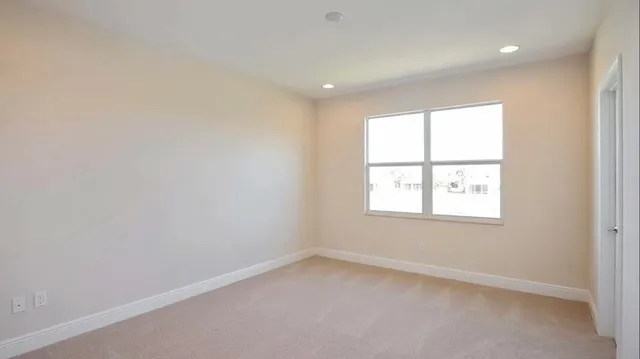 a spacious bedroom with a bed and a ceiling fan