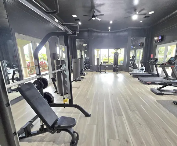 a living room with couches a chandelier and a dining table with a large window