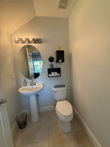 a bathroom with a toilet a sink and mirror