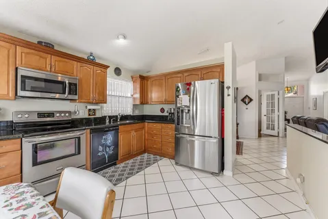 a kitchen with stainless steel appliances granite countertop a refrigerator stove top oven and sink