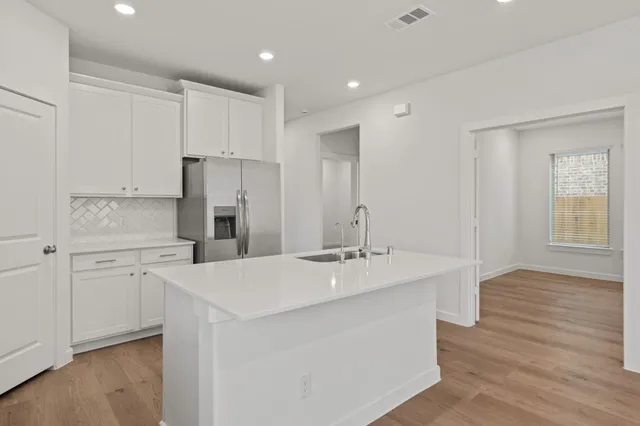 a kitchen with kitchen island a sink stove and refrigerator
