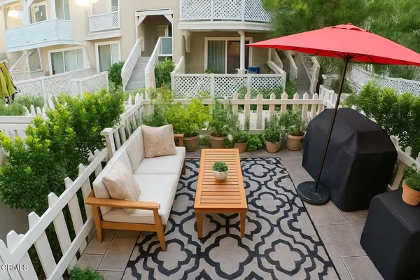 a view of a patio with furniture and a garden