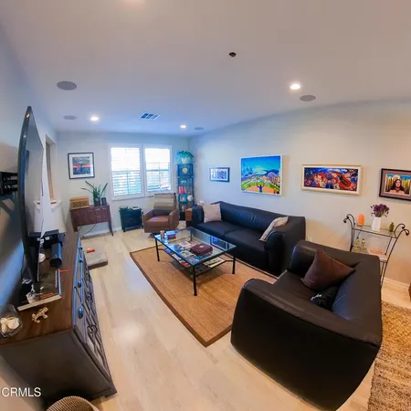 a living room with furniture a flat screen tv and a window