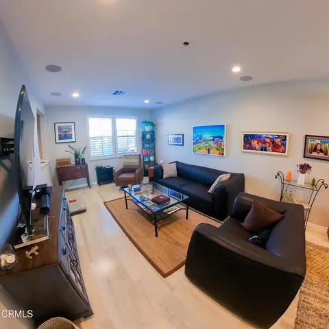 a living room with furniture a flat screen tv and a window